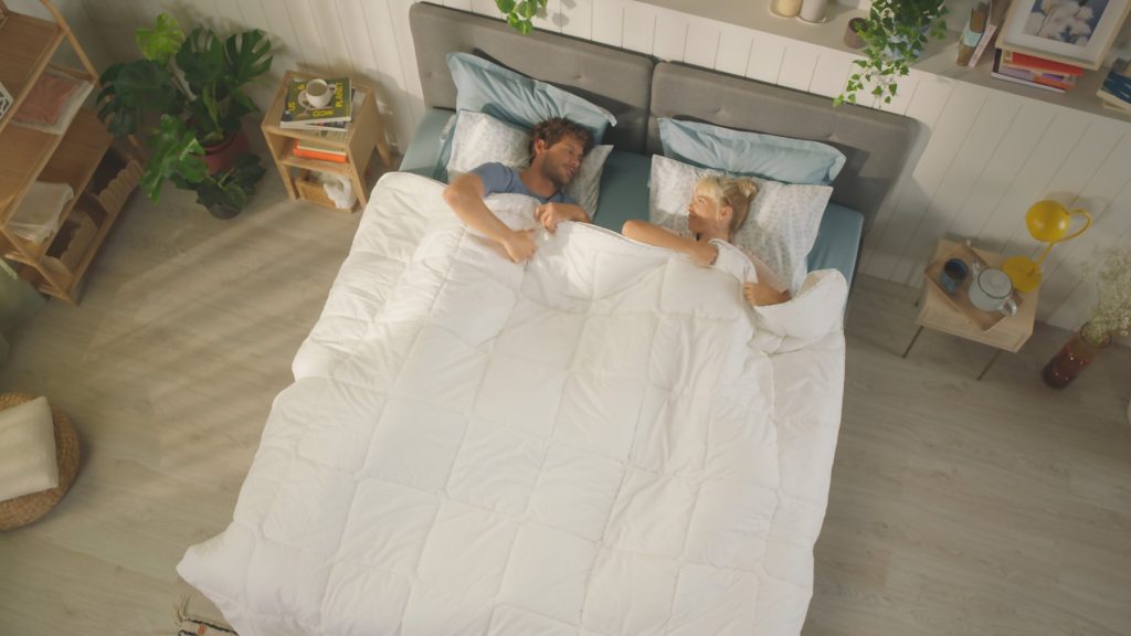 Couple under the Emma All Seasons duvet seen from above