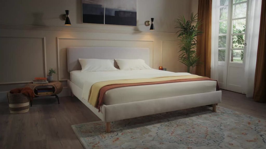 Emma Box Bed in beige seen from the side in a furnished bedroom