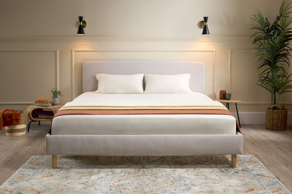 Emma Box Bed in beige with upholstered headboard, front view in a bedroom
