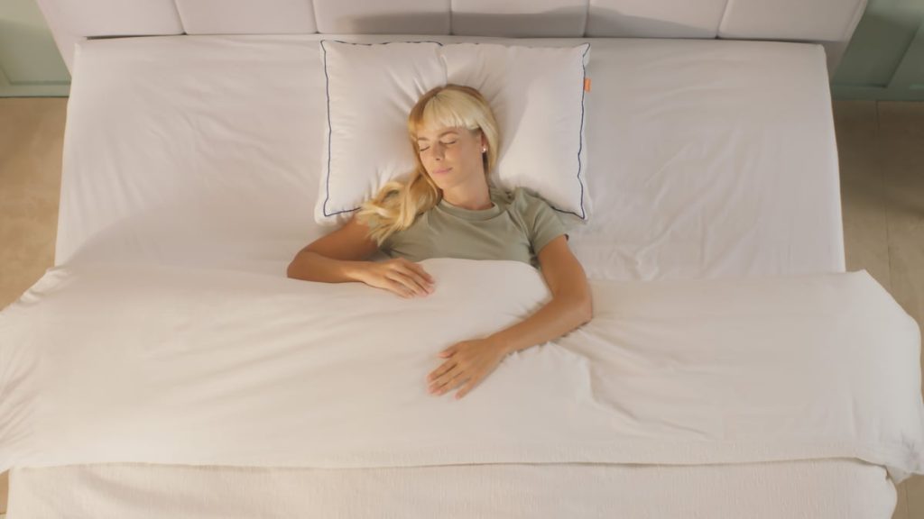Woman asleep on her back on an Emma Comfort Cooling Pillow
