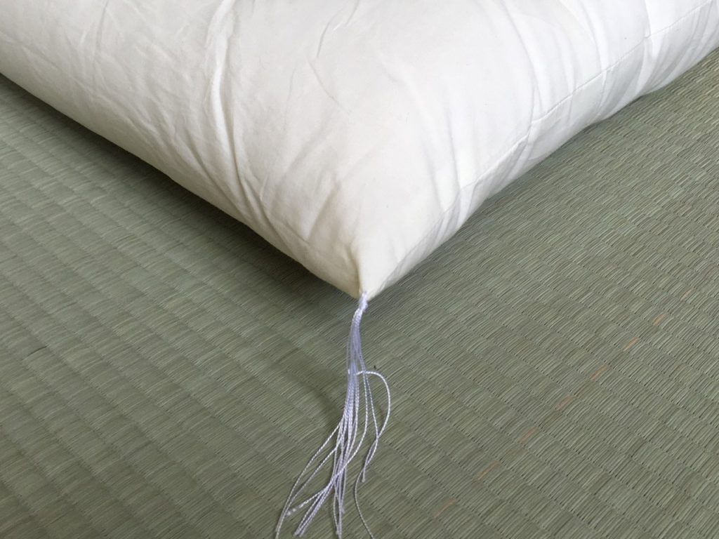 Corner of a white Futons from Japan shikibuton showing the hand-tied tufting thread