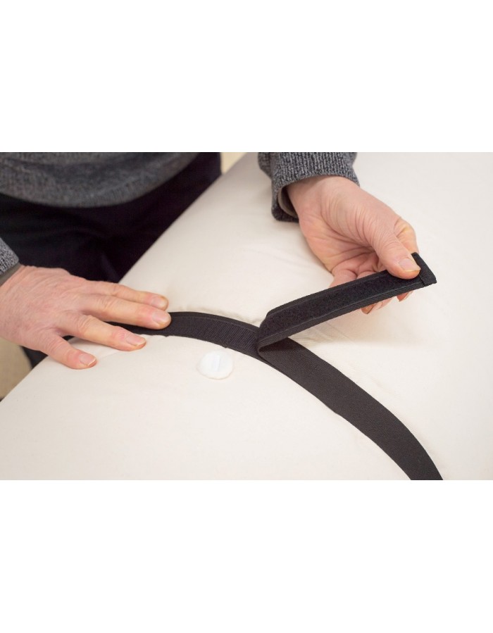 Hands fastening the hook-and-loop storage strap of a Futons247 Monk bed roll