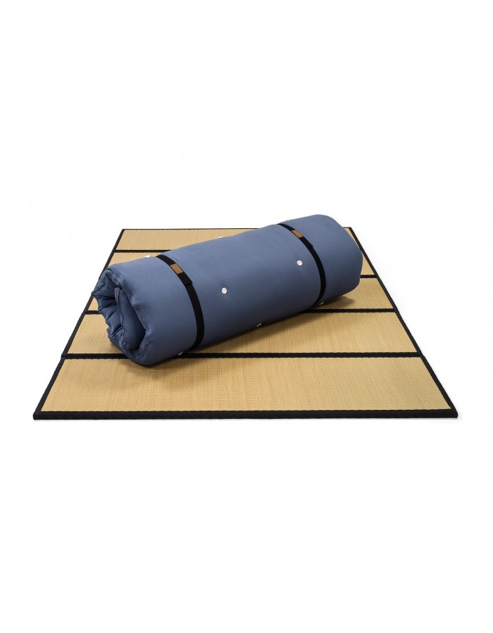 Futons247 Neru bed roll in blue rolled up and strapped on a tatami mat