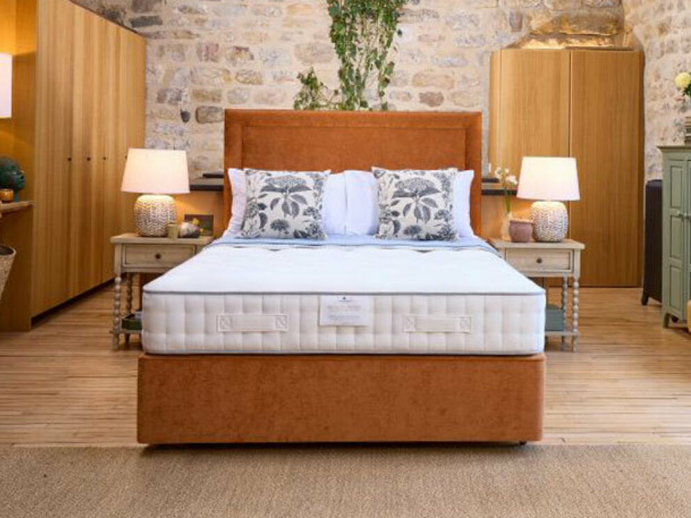 Harrison Spinks Bronze Ortho 3500 mattress on an orange divan in a stone-walled bedroom