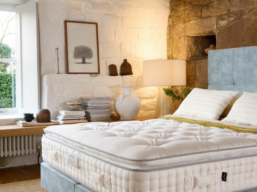 Harrison Spinks Radiant Pillowtop 15000 mattress on a blue divan beside a stone fireplace