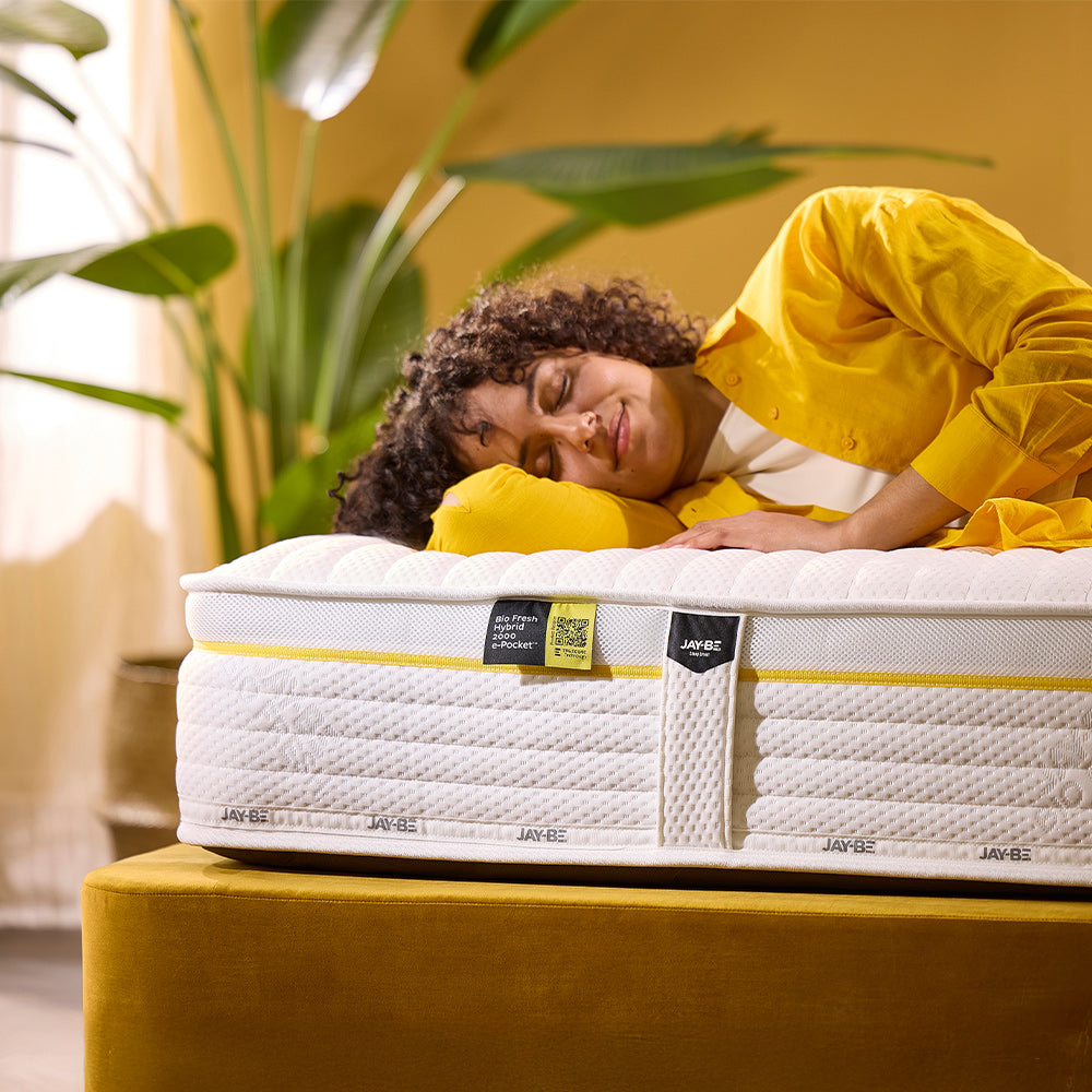 Woman resting on the edge of a Jay-Be Bio Fresh Hybrid 2000 mattress