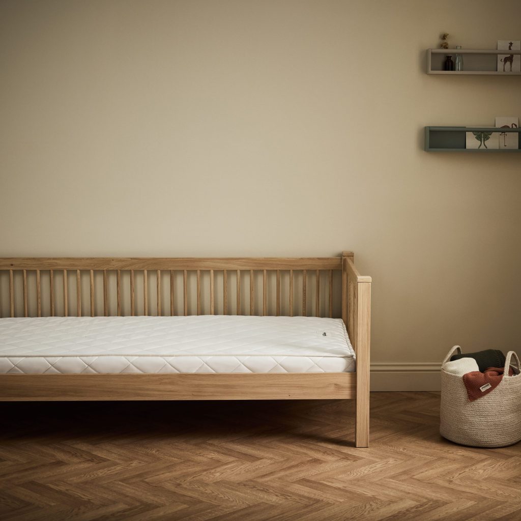 The Little Green Sheep Natural Junior Mattress on a wooden children's single bed