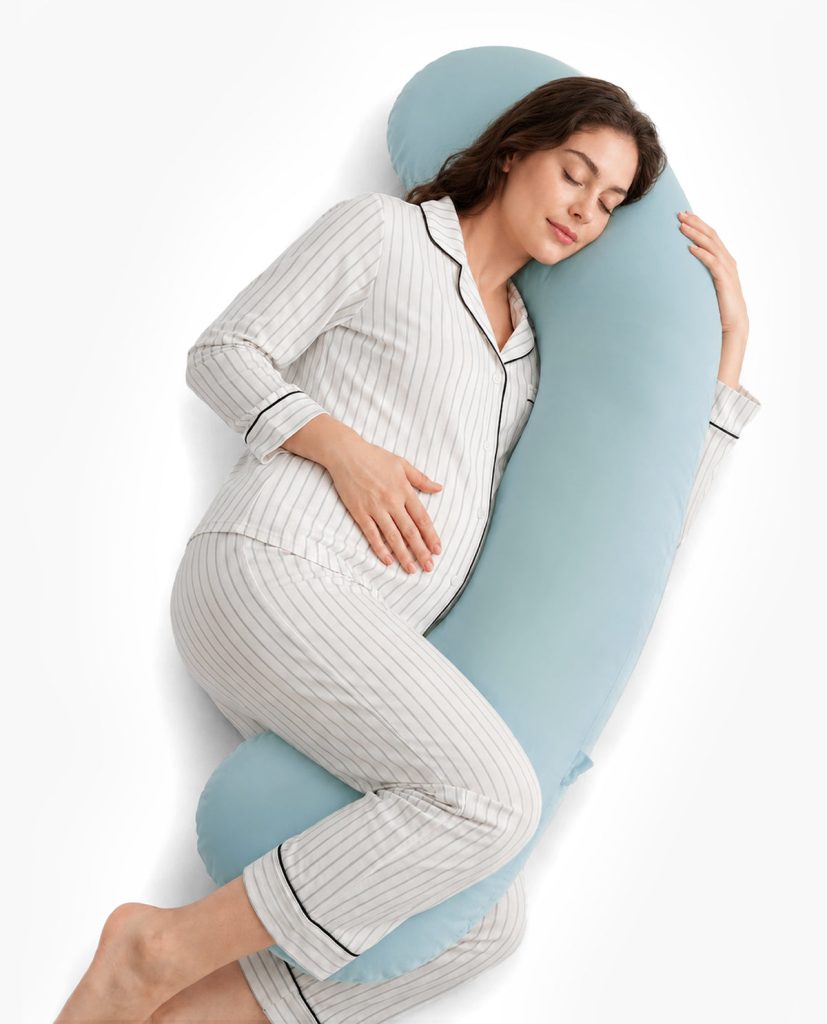 Momcozy J-shaped pillow with the blue cooling cover, used by a pregnant woman on her side