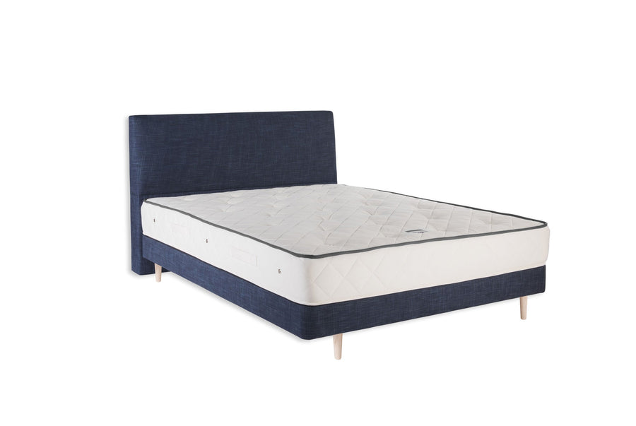 Naturalmat Mohair Mattress on a navy upholstered bed, white background