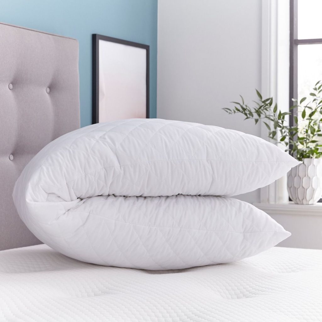 Silentnight Body Support Pillow folded in half on a bed, seen from the side