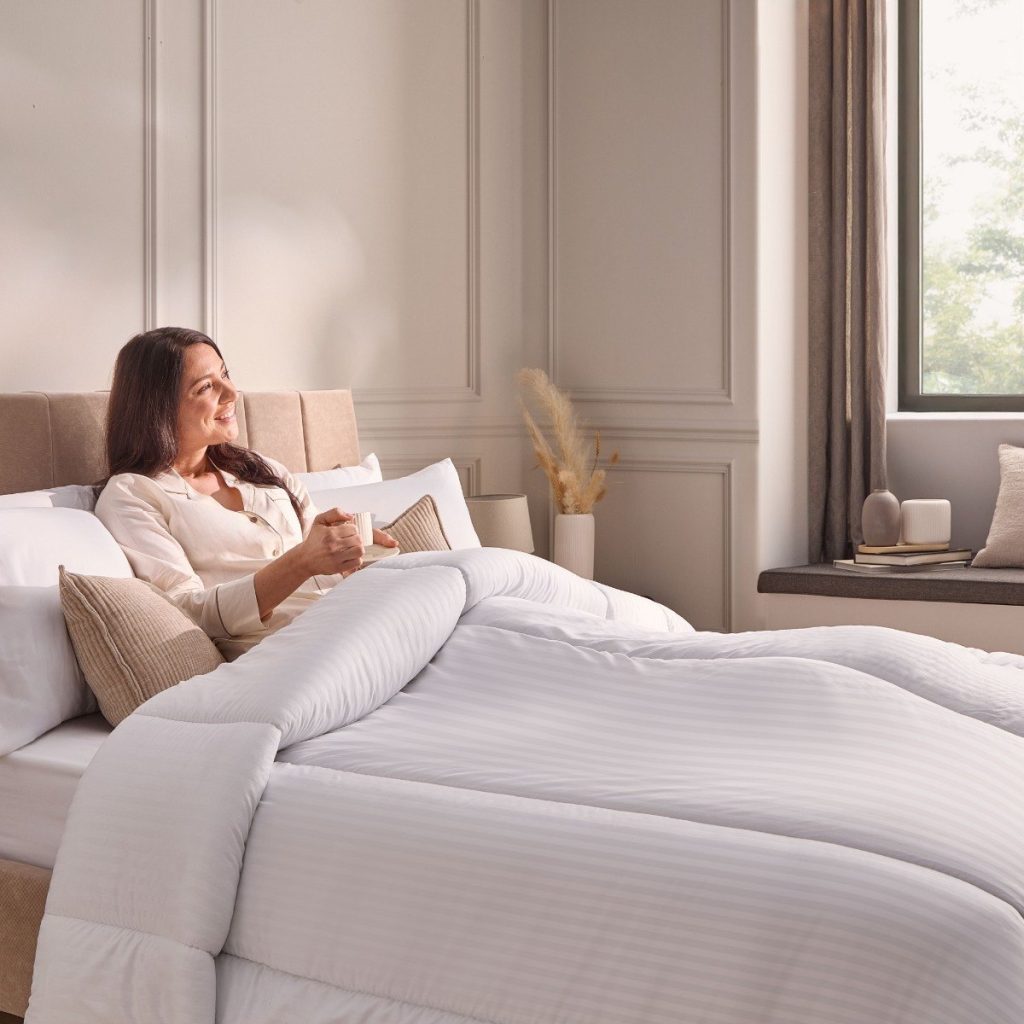Woman reading in bed under the Silentnight Hotel Collection duvet