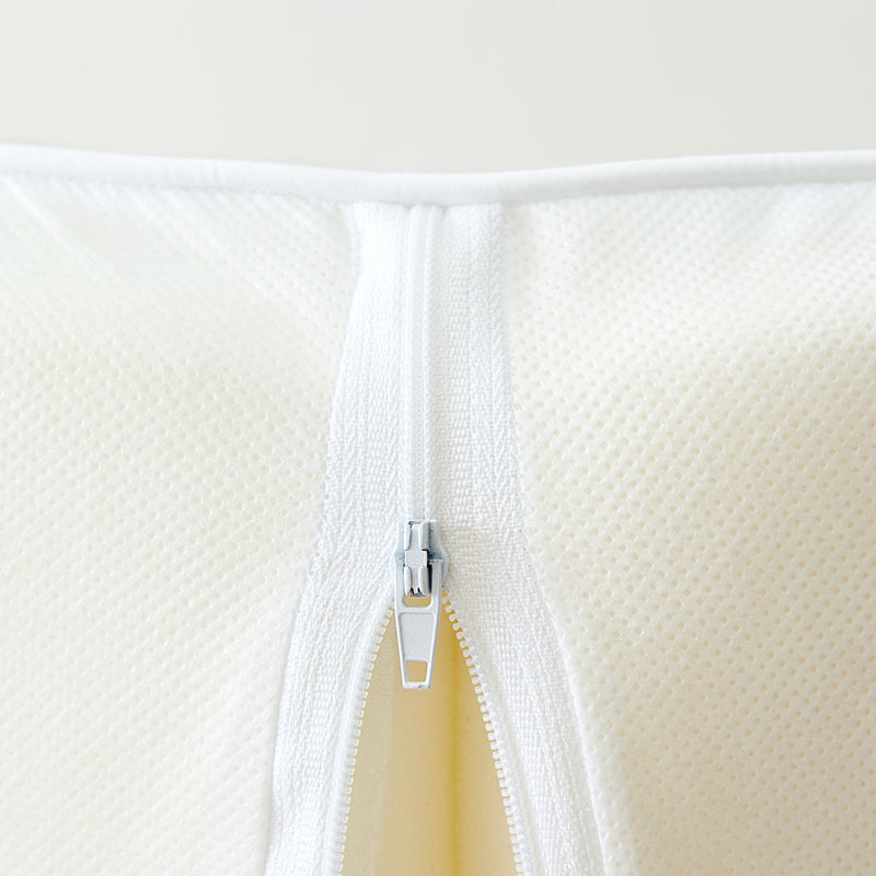 Tiny Dreamer foam travel cot mattress with the cover unzipped to show the foam core