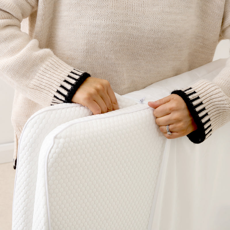 Zipping the removable cover onto a Tiny Dreamer Natural travel cot mattress